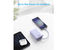 Charger l'image dans la galerie, Table blanche avec téléphone se chargeant d'une batterie externe. Écouteurs à proximité. Texte dit 'All-in-One Power On the Move'.