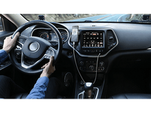 Charger l'image dans la galerie, Personne conduisant une voiture, tenant le volant, avec un téléphone sur le tableau de bord.