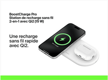 Charger l'image dans la galerie, Un téléphone en charge sur un socle de charge blanc avec un étui pour écouteurs, sur fond blanc.