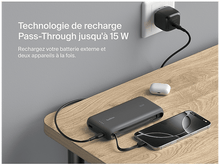 Charger l'image dans la galerie, Batterie externe chargeant un téléphone et se chargeant, près d'une prise murale.