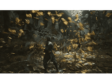 Charger l'image dans la galerie, Une personne vêtue de sombre se trouve dans une forêt avec des feuilles dorées tourbillonnant autour d'elle.
