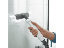 Charger l'image dans la galerie, Une main utilisant un nettoyeur vapeur sur une surface vitrée.