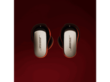 Charger l'image dans la galerie, Écouteurs Bose sur fond rouge. Les écouteurs sont noirs et argentés avec le logo Bose.