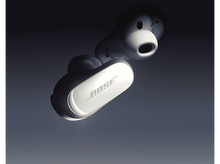 Charger l'image dans la galerie, Écouteurs Bose blancs, un avec un visage de dessin animé, sur fond dégradé sombre.