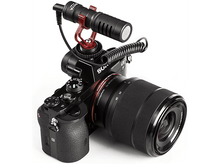 Charger l'image dans la galerie, Un appareil photo avec un microphone et un objectif attachés, orienté vers le haut.