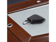 Charger l'image dans la galerie, Un microphone noir avec une housse en maille sur une surface en bois.