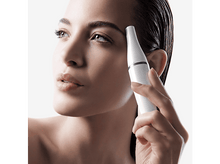 Charger l'image dans la galerie, Femme avec un appareil blanc près de son œil. Elle regarde vers le haut avec une expression neutre.