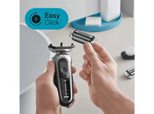 Charger l'image dans la galerie, Les mains d'un homme tenant un rasoir et une nouvelle tête de rasoir.