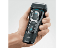 Charger l'image dans la galerie, Une main tenant un rasoir Braun Series 5 Wet & Dry noir, sur un fond clair.