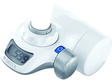 Charger l'image dans la galerie, Un évier avec un filtre à eau Brita. L'eau coule du filtre. Une main tourne le robinet.