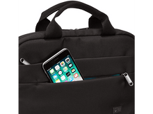 Charger l'image dans la galerie, Sac noir avec un téléphone dans la poche avant. Le téléphone a des icônes d'applications.