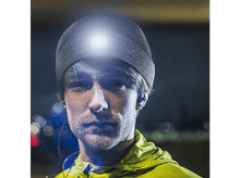 Charger l'image dans la galerie, Un homme portant un bonnet gris avec une lumière intégrée, dans un environnement sombre.