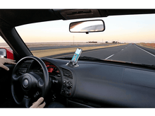 Charger l'image dans la galerie, Intérieur de voiture avec téléphone sur le tableau de bord, sur autoroute.