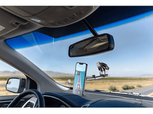 Charger l'image dans la galerie, Intérieur de voiture avec un téléphone monté sur le tableau de bord. La carte GPS est affichée sur l'écran du téléphone.