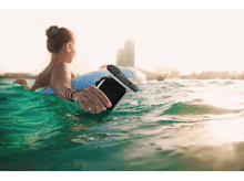 Charger l'image dans la galerie, Une femme dans l'eau avec un téléphone dans un étui étanche, sur un flotteur donut, éclairé par le soleil.