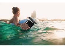 Charger l'image dans la galerie, Une femme sur un dispositif flottant tient un téléphone dans un étui étanche.