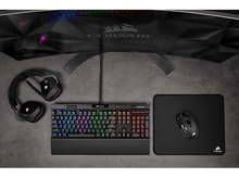 Charger l'image dans la galerie, Une configuration de jeu avec un clavier et une souris éclairés par des lumières RVB, et un écran incurvé.