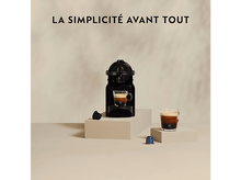 Charger l'image dans la galerie, Machine à café avec une tasse de café et des capsules sur une surface blanche.