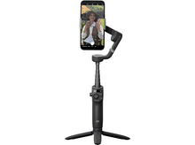 Charger l'image dans la galerie, Un téléphone est monté sur un stabilisateur noir. Une femme à l'écran salue, tenant une tasse.