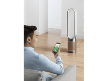 Charger l'image dans la galerie, Homme utilisant un smartphone pour contrôler un purificateur d'air Dyson dans un salon.