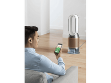 Charger l'image dans la galerie, Homme utilisant un smartphone pour contrôler un purificateur d'air Dyson avec réservoir d'eau salon.