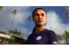 Charger l'image dans la galerie, Une femme en maillot de foot violet regarde en l'air, contre un ciel nuageux.