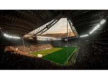 Charger l'image dans la galerie, Vue panoramique d'un stade bondé, d'un terrain vert et d'un coucher de soleil.