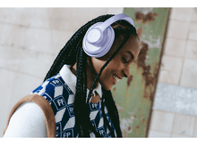 Charger l'image dans la galerie, Une femme avec des tresses portant un casque lavande et un pull à motifs.