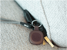 Charger l'image dans la galerie, Un porte-clés avec des clés et un traceur, posé sur un canapé.