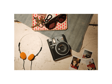 Charger l'image dans la galerie, Un appareil photo Instax Mini 41 est posé sur une table blanche avec des clés, des lunettes de soleil et un casque.