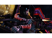 Charger l'image dans la galerie, Une personne avec un casque vise avec une arme tout en étant assise sur un véhicule endommagé la nuit.