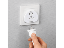 Charger l'image dans la galerie, Adaptateur secteur blanc branché sur une prise murale, avec une main tenant la prise.