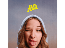 Charger l'image dans la galerie, Une jeune femme fait un clin d'œil et tire la langue. Elle porte un sweat à capuche bleu avec du texte jaune.