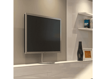 Charger l'image dans la galerie, Un téléviseur monté sur un mur. Il a un cadre argenté et se trouve au-dessus d'un meuble blanc avec des éléments de décoration.