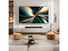 Charger l'image dans la galerie, Une grande TV murale au-dessus d'un meuble, d'une barre de son et d'objets décoratifs.