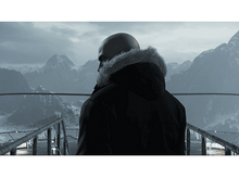 Charger l'image dans la galerie, Homme chauve en veste noire, regardant des montagnes enneigées.