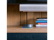 Charger l'image dans la galerie, Hub domotique sur une surface en bois, avec des livres et une barre de son en arrière-plan.