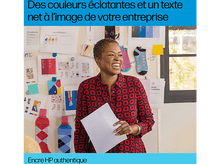 Charger l'image dans la galerie, Femme souriante tenant des papiers dans une pièce avec des papiers épinglés au mur.