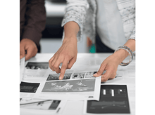 Charger l'image dans la galerie, Deux personnes pointant un document avec des graphiques et une carte.