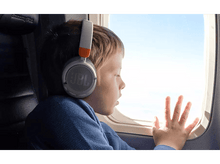Charger l'image dans la galerie, Un enfant portant un casque JBL gris regarde par la fenêtre d'un avion.