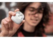 Charger l'image dans la galerie, Une personne tenant un étui blanc avec deux écouteurs blancs, le logo JBL est visible.