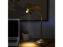 Charger l'image dans la galerie, Une lampe dorée en forme de vif d'or est posée sur un bureau en bois avec un ordinateur portable.