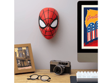 Charger l'image dans la galerie, Masque de Spider-Man sur un mur. Un appareil photo, des lunettes et un ordinateur sur un bureau en bois.