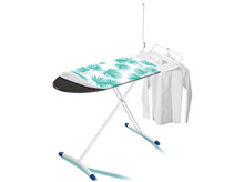 Charger l'image dans la galerie, Une table à repasser avec des pieds blancs, un motif de palmiers turquoise et une chemise blanche sur un cintre.