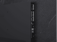 Charger l'image dans la galerie, Vue arrière d'une TV montrant les ports et connexions sur une surface en marbre foncé.