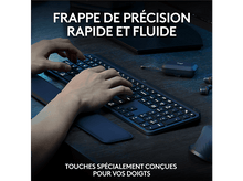 Charger l'image dans la galerie, Mains tapant sur un clavier bleu foncé sur un bureau en bois avec repose-poignets.