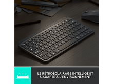 Charger l'image dans la galerie, Un clavier gris foncé avec des touches éclairées sur une table en bois.