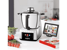 Charger l'image dans la galerie, Un robot culinaire Magimix argent et noir avec un livre de cuisine rouge et un iPad sur un comptoir blanc.