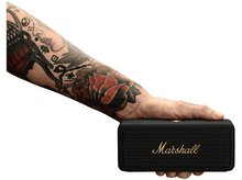 Charger l'image dans la galerie, Une personne tenant un haut-parleur Marshall noir. Le haut-parleur a un logo Marshall doré.