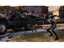 Charger l'image dans la galerie, Spider-Man en costume noir combattant une figure sombre et ombragée à côté d'un véhicule.